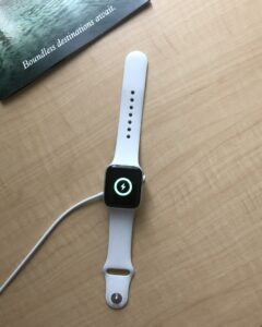 Apple Watch overhead being changed on wooden table & Boundless destination await text. Technology