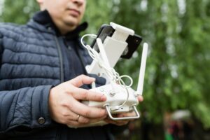 Young caucasian man using technology outdoor. Remote control for drone DJI phantom