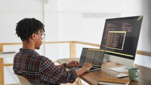 Homme qui fait du code informatique sur son ordinateur