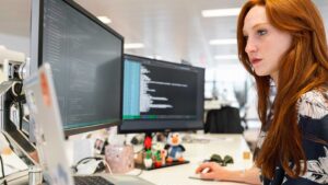 Femme qui fait du code informatique sur un ordinateur