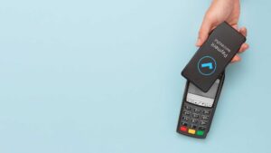 Paiement sans contact depuis un téléphone sur un TPE sur un fond bleu